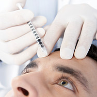 Ein Arzt injeziert einer Patientin Botulinumtoxin (Botox) in die Stirn gegen ihre Falten.
