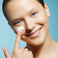 Eine junge Frau cremt ihr Gesicht ein, da sie ihren Hauttyp dank der Pflegeberatung kennt. 